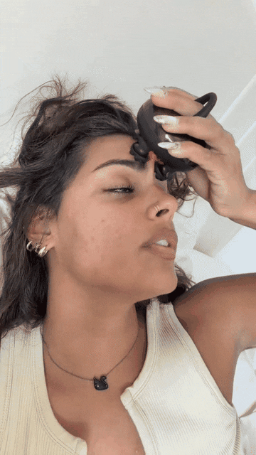 Demonstration of gently guiding the massager along the forehead and scalp